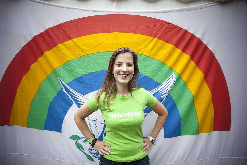 Greenpeace Activist standing in front of iconic Greenpeace Rainbow